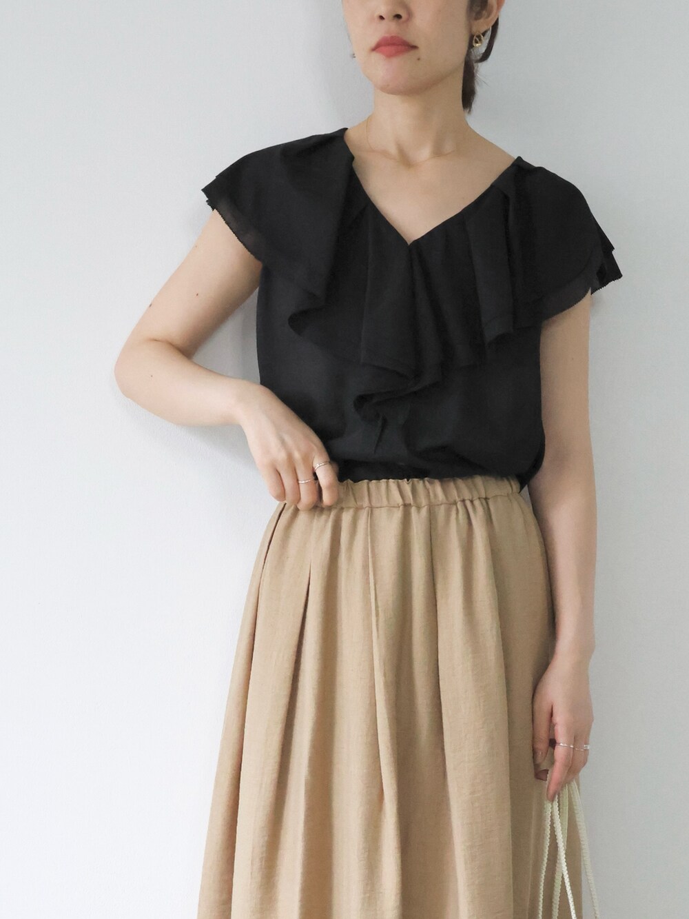 ブラック系のシャツ/ブラウス、ベージュ系のスカート、ブラック系のサンダルを着用したレディースの夏コーディネートの6枚目の写真