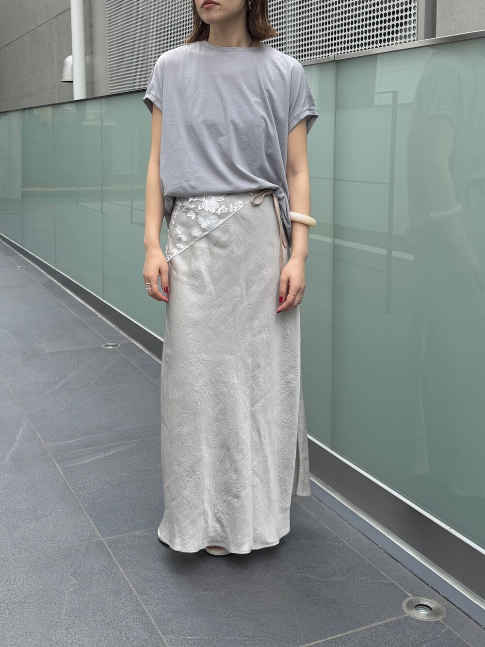 グレー系のスカート、グレー系のTシャツ/カットソーを着用したレディースの夏コーディネートの4枚目の写真