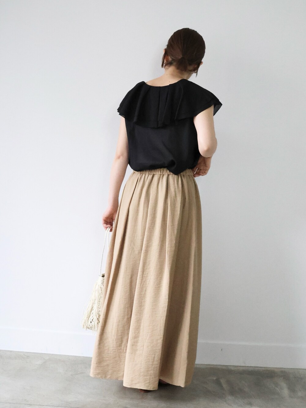 ブラック系のシャツ/ブラウス、ベージュ系のスカート、ブラック系のサンダルを着用したレディースの夏コーディネートの3枚目の写真