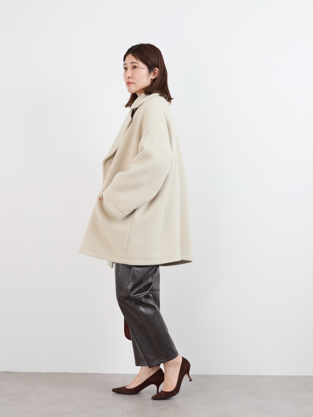 ブラウン系のスウェット、ホワイト系のTシャツ/カットソー、ベージュ系のピーコートを着用したレディースの冬コーディネートの4枚目の写真