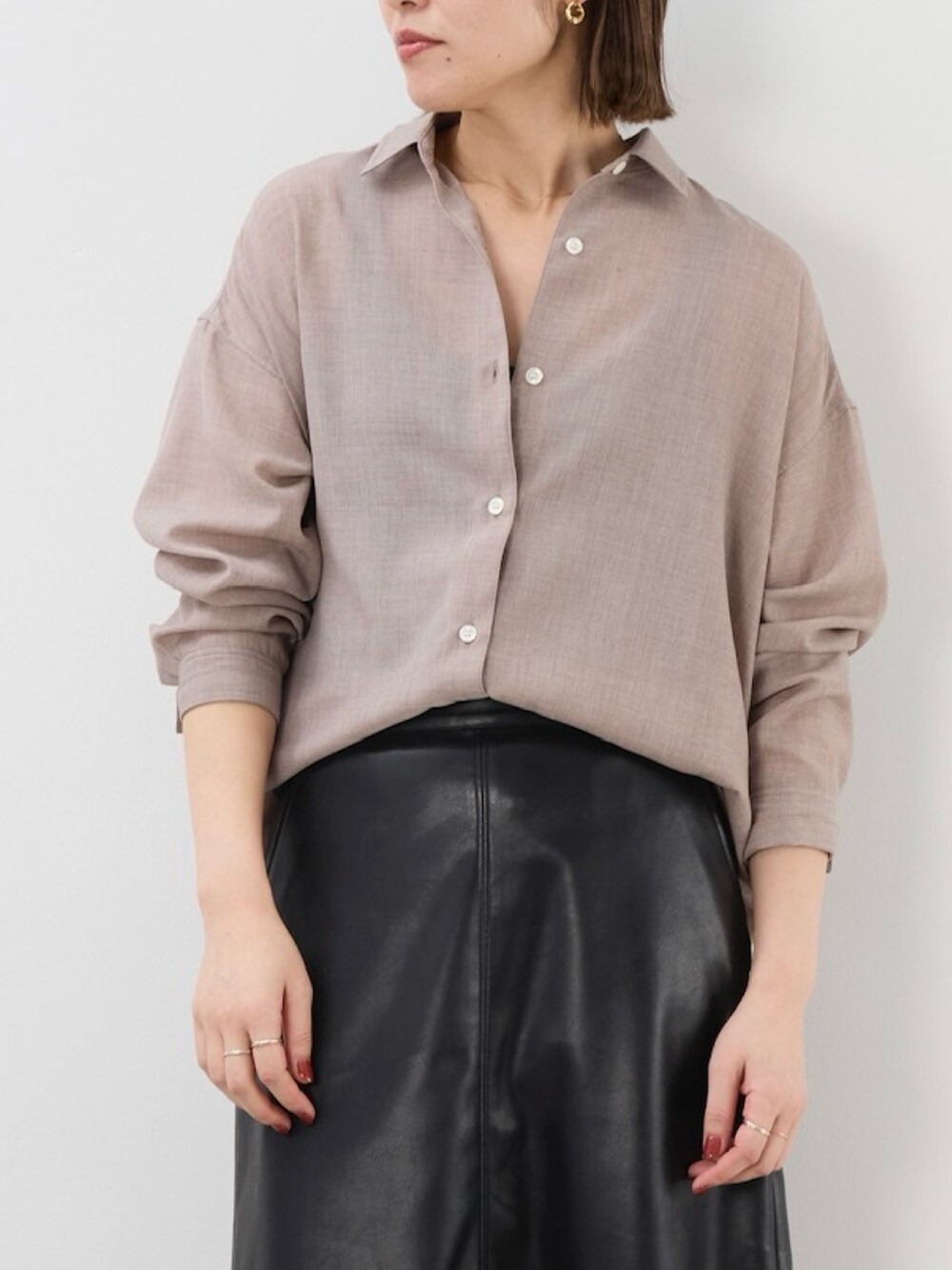 ブラック系のスカート、ベージュ系のシャツ/ブラウスを着用したレディースの秋コーディネートの2枚目の写真