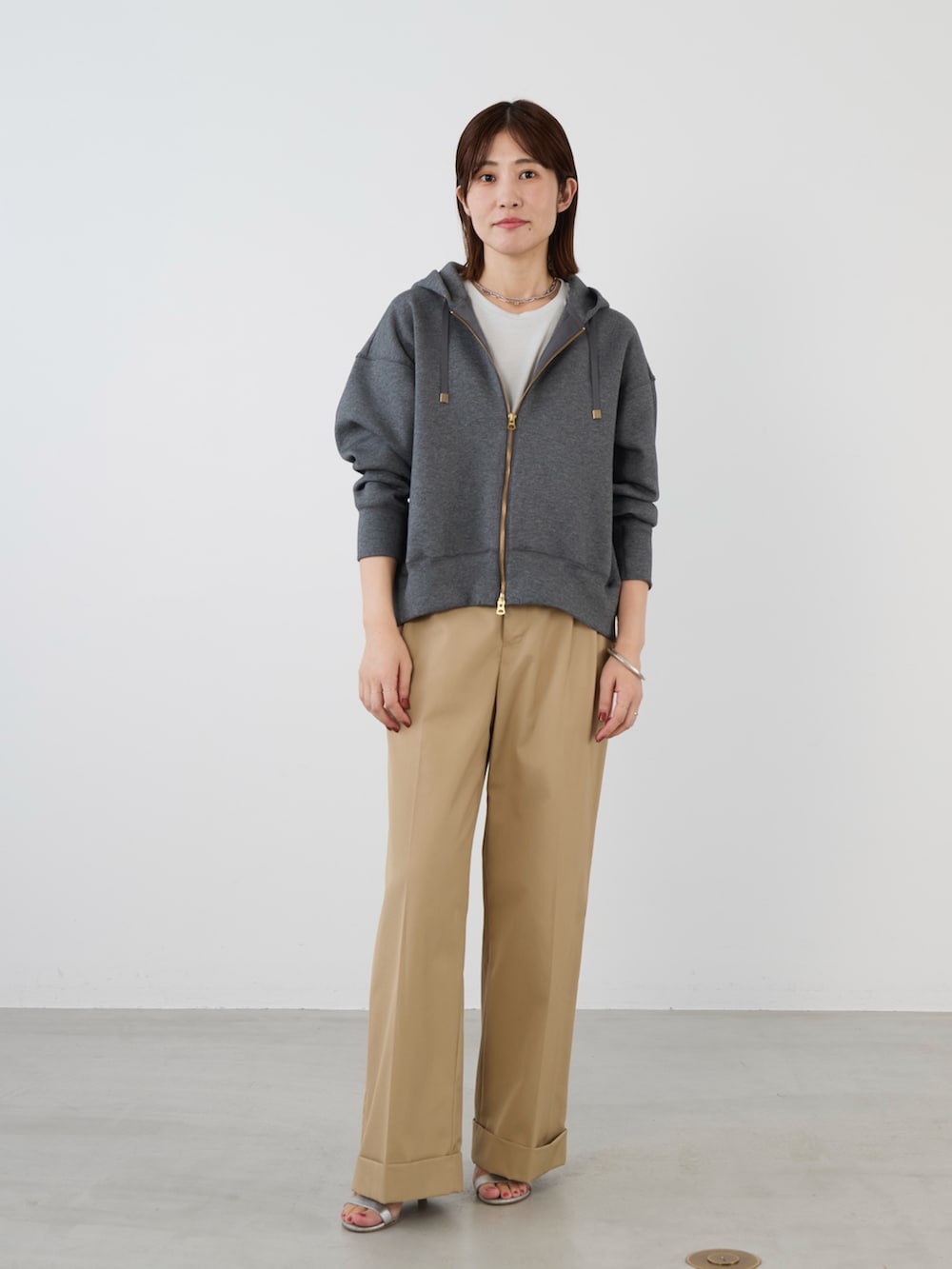 グレー系のパーカーを着用したレディースの冬コーディネートの2枚目の写真