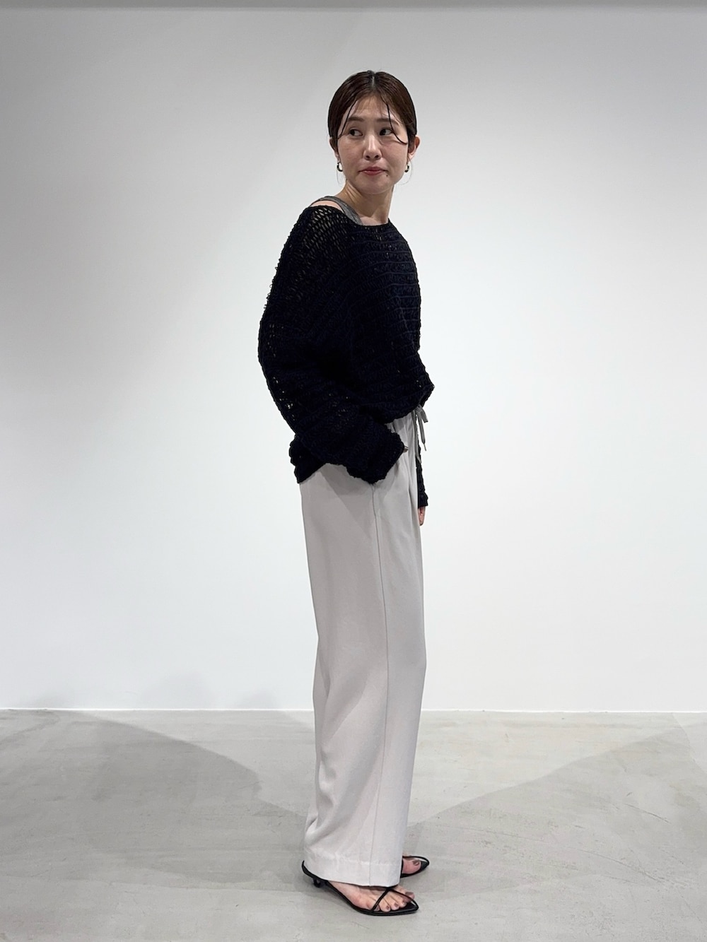 ホワイト系のその他パンツ、ブラック系のニット/セーター、グレー系のタンクトップを着用したレディースの春コーディネートの7枚目の写真