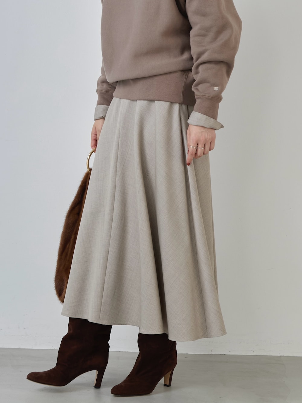 ベージュ系のスカート、ベージュ系のシャツ/ブラウス、ブラウン系のスウェットを着用したレディースの冬コーディネートの5枚目の写真