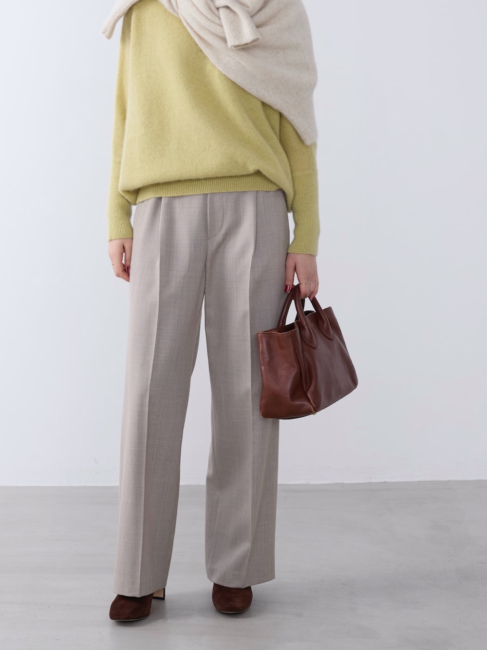 イエロー系のニット/セーター、ホワイト系のニット/セーター、ベージュ系のその他パンツを着用したレディースの冬コーディネートの2枚目の写真