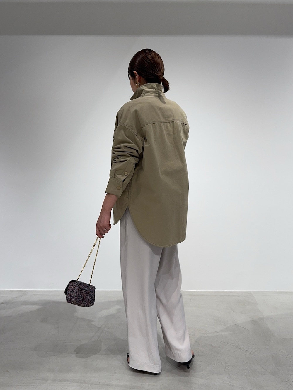 ベージュ系のシャツ/ブラウス、ブラック系のニット/セーター、その他のショルダーバッグを着用したレディースの春コーディネートの7枚目の写真