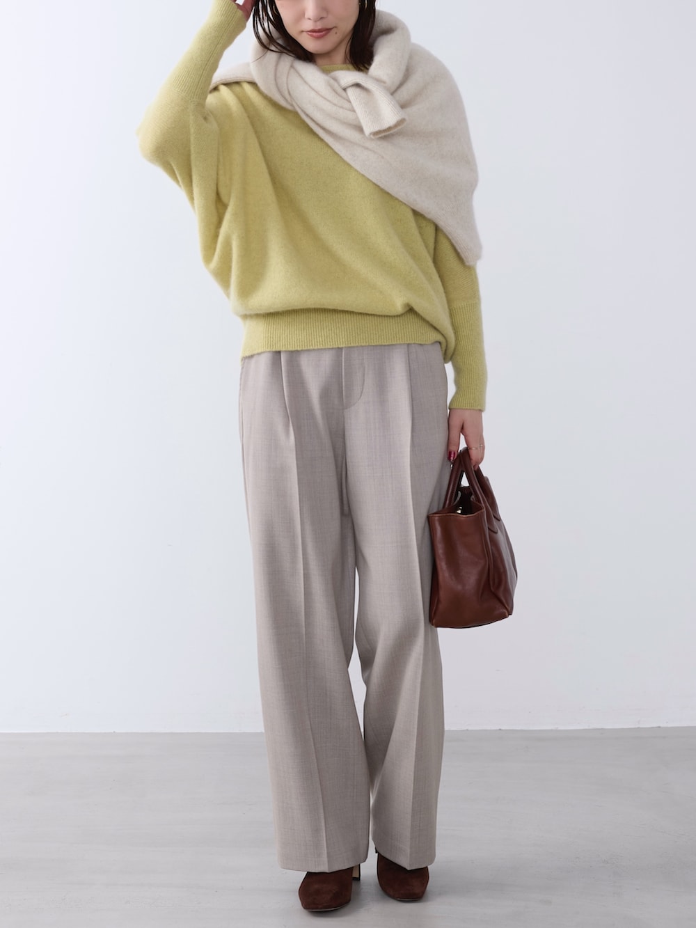 イエロー系のニット/セーター、ホワイト系のニット/セーター、ベージュ系のその他パンツを着用したレディースの冬コーディネートの4枚目の写真