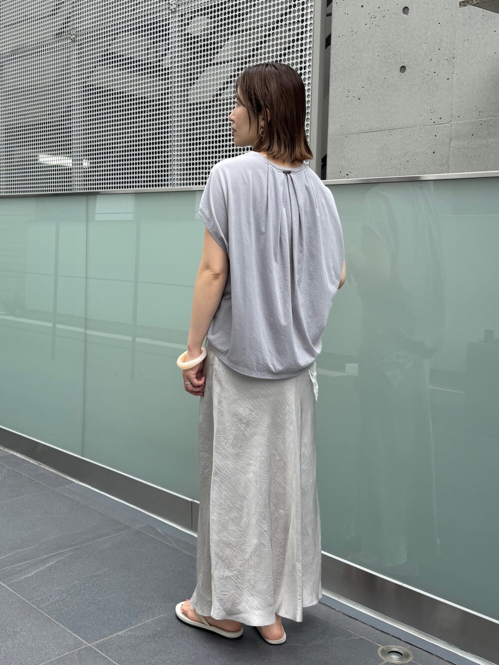 グレー系のスカート、グレー系のTシャツ/カットソーを着用したレディースの夏コーディネートの5枚目の写真