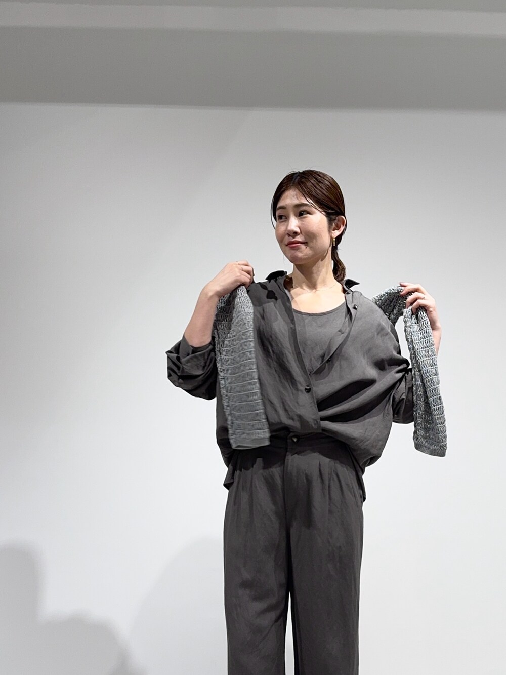 グリーン系のシャツ/ブラウス、グレー系のニット/セーター、グリーン系のその他パンツを着用したレディースの春コーディネートの6枚目の写真