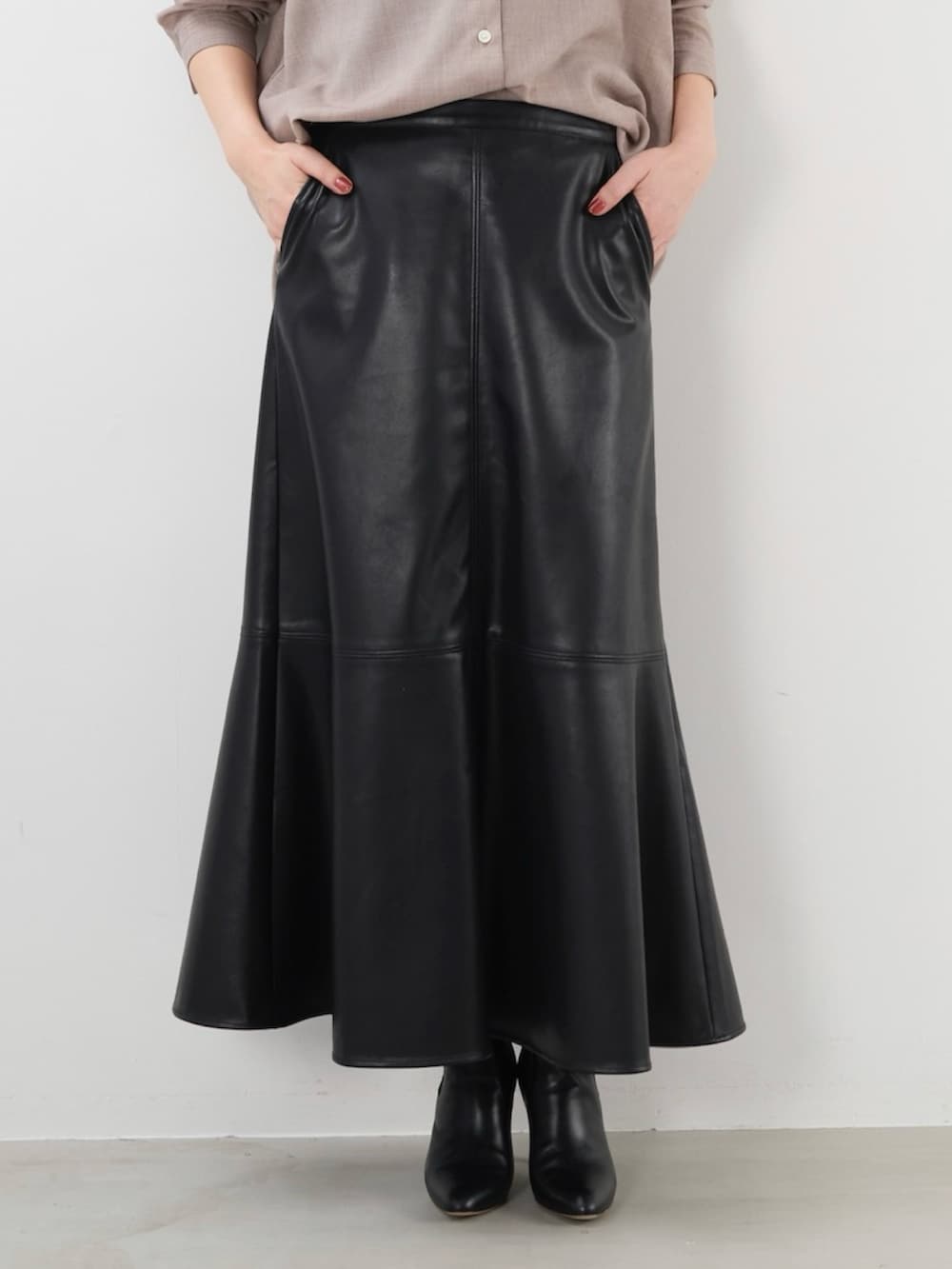 ブラック系のスカート、ベージュ系のシャツ/ブラウスを着用したレディースの秋コーディネートの3枚目の写真