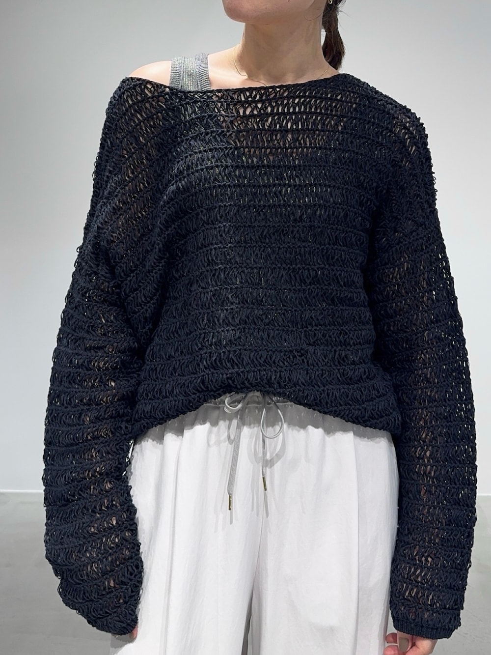 ホワイト系のその他パンツ、ブラック系のニット/セーター、グレー系のタンクトップを着用したレディースの春コーディネートの5枚目の写真