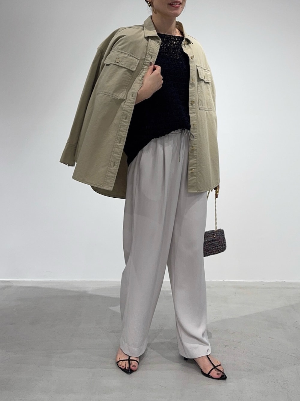 ベージュ系のシャツ/ブラウス、ブラック系のニット/セーター、その他のショルダーバッグを着用したレディースの春コーディネートの3枚目の写真