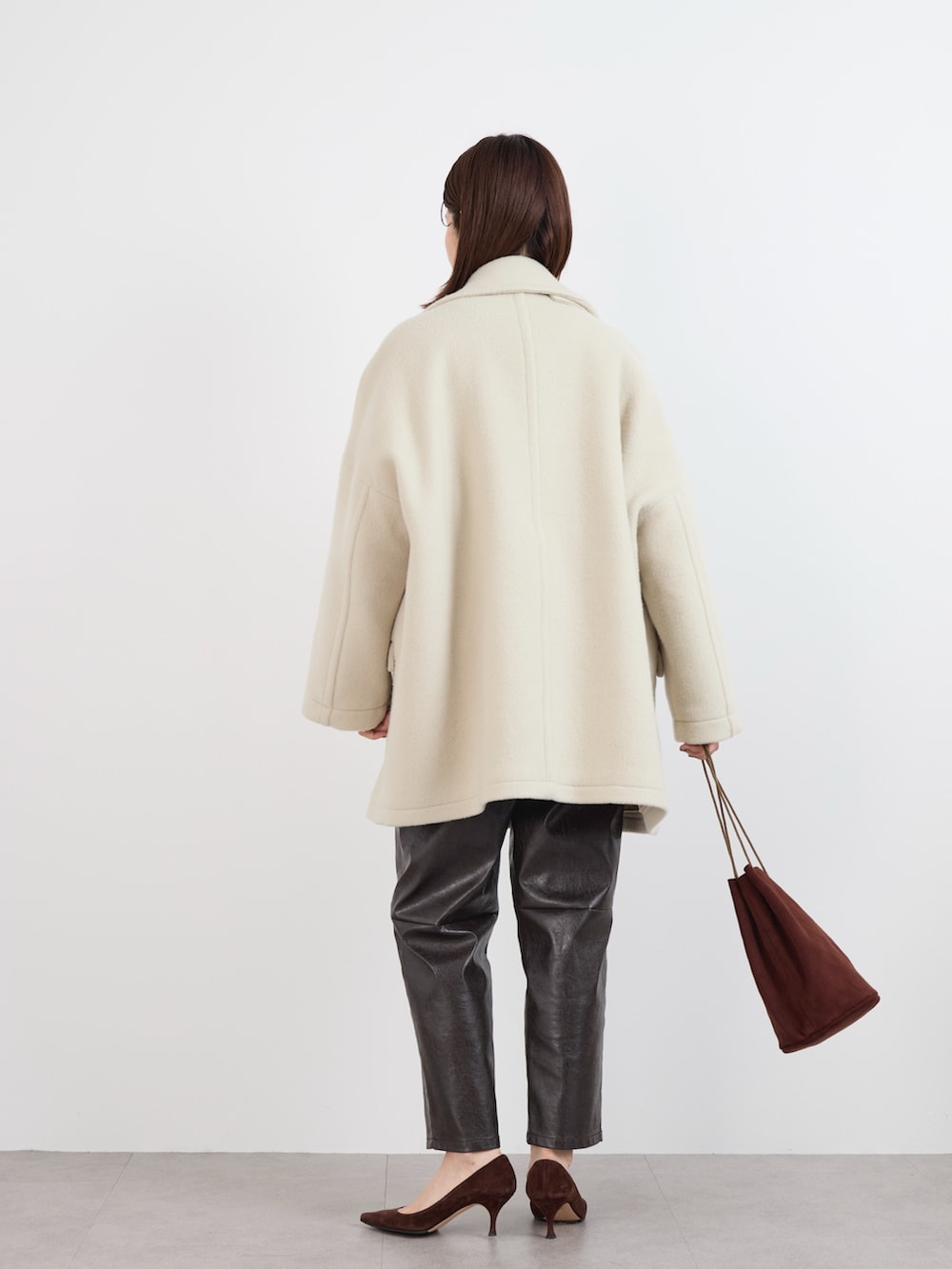 ブラウン系のスウェット、ホワイト系のTシャツ/カットソー、ベージュ系のピーコートを着用したレディースの冬コーディネートの5枚目の写真