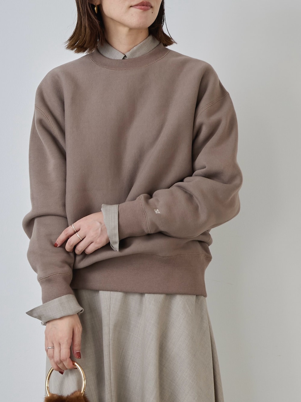 ベージュ系のスカート、ベージュ系のシャツ/ブラウス、ブラウン系のスウェットを着用したレディースの冬コーディネートの3枚目の写真