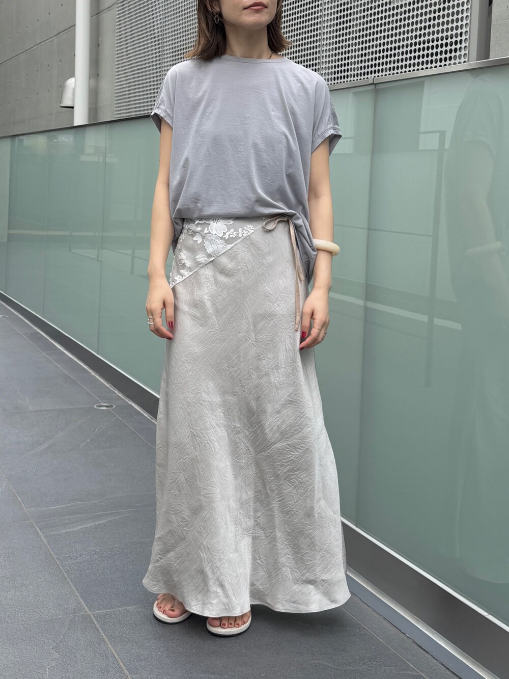 グレー系のスカート、グレー系のTシャツ/カットソーを着用したレディースの夏コーディネートの3枚目の写真