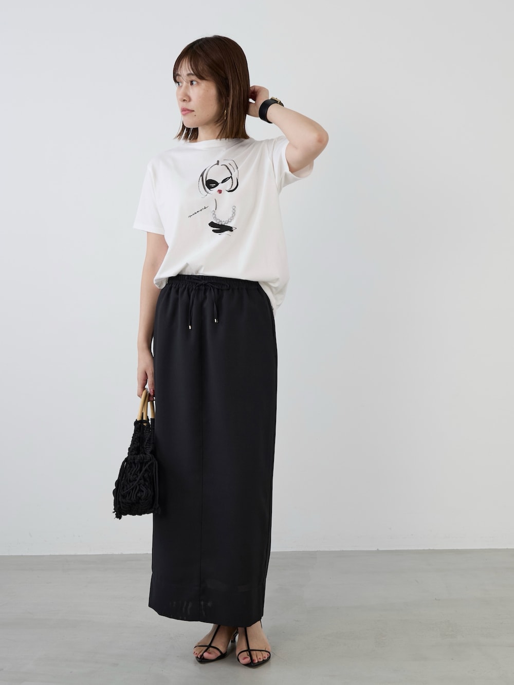 ホワイト系のTシャツ/カットソー、ブラック系のスカートを着用したレディースの春コーディネートの3枚目の写真