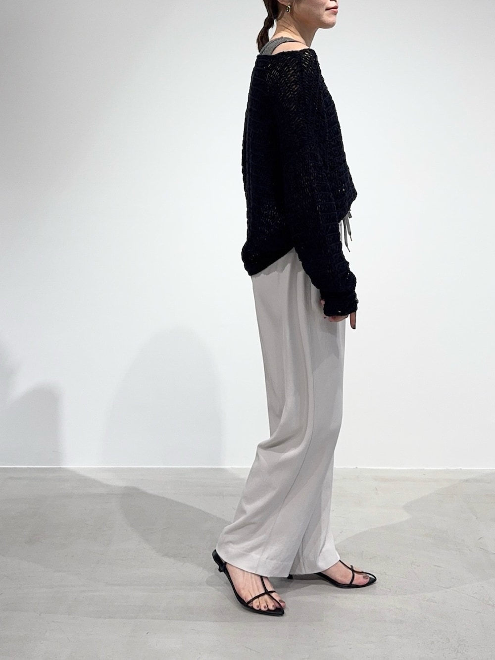 ホワイト系のその他パンツ、ブラック系のニット/セーター、グレー系のタンクトップを着用したレディースの春コーディネートの6枚目の写真