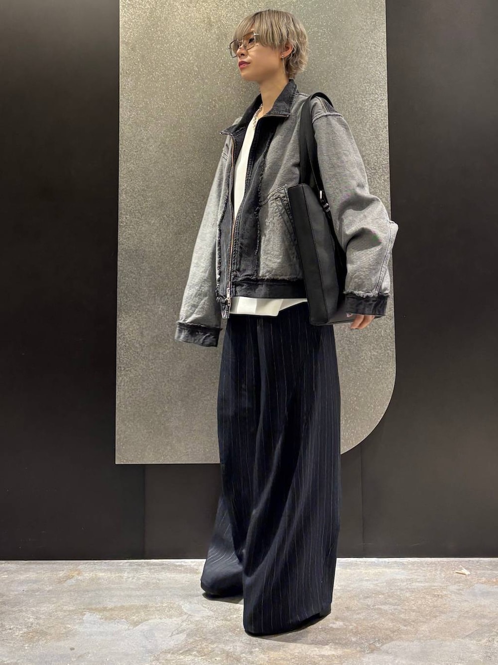 ブラック系のブーツ、ブラック系のトートバッグ、ホワイト系のスウェットを着用したレディースの冬コーディネートの2枚目の写真