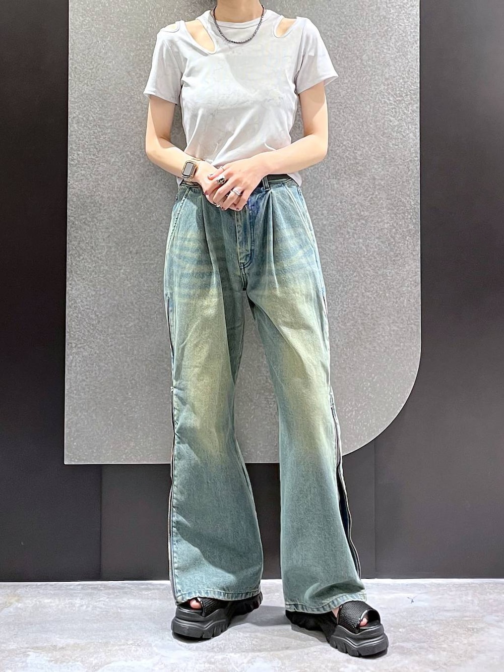 ブルー系のデニムパンツ、ブラック系のサンダル、ホワイト系のTシャツ/カットソーを着用したレディースの夏コーディネートの2枚目の写真