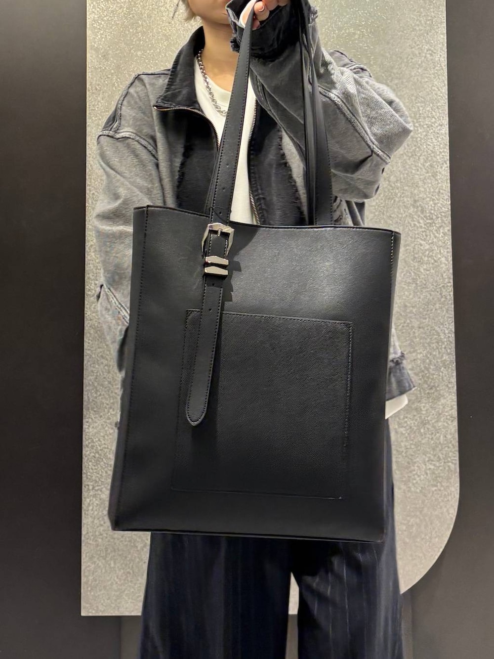 ブラック系のブーツ、ブラック系のトートバッグ、ホワイト系のスウェットを着用したレディースの冬コーディネートの4枚目の写真