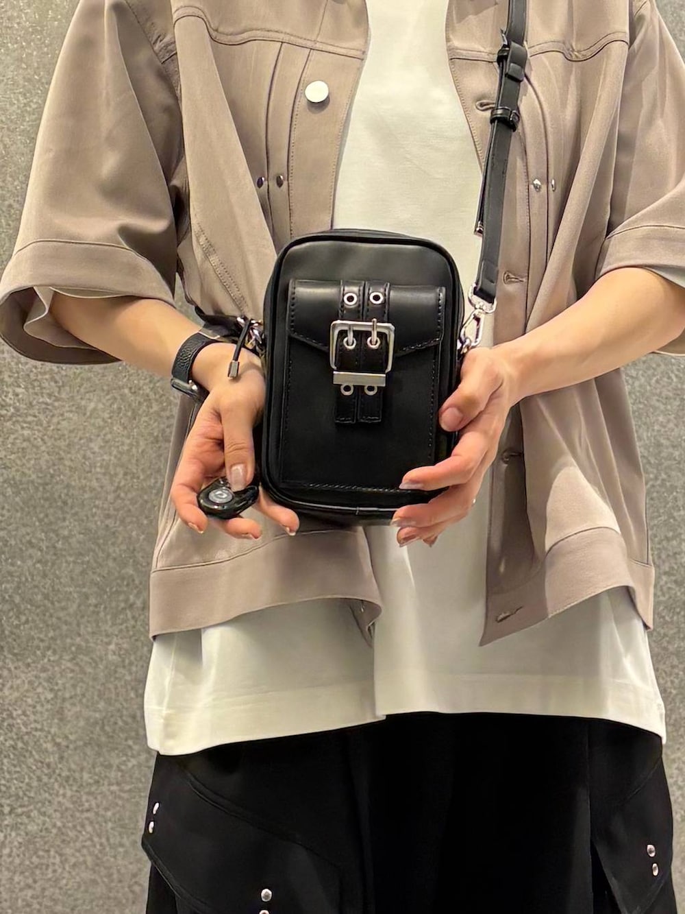 ブラック系のサンダル、ブラック系のカーゴパンツ、ブラック系のショルダーバッグを着用したレディースの春コーディネートの4枚目の写真