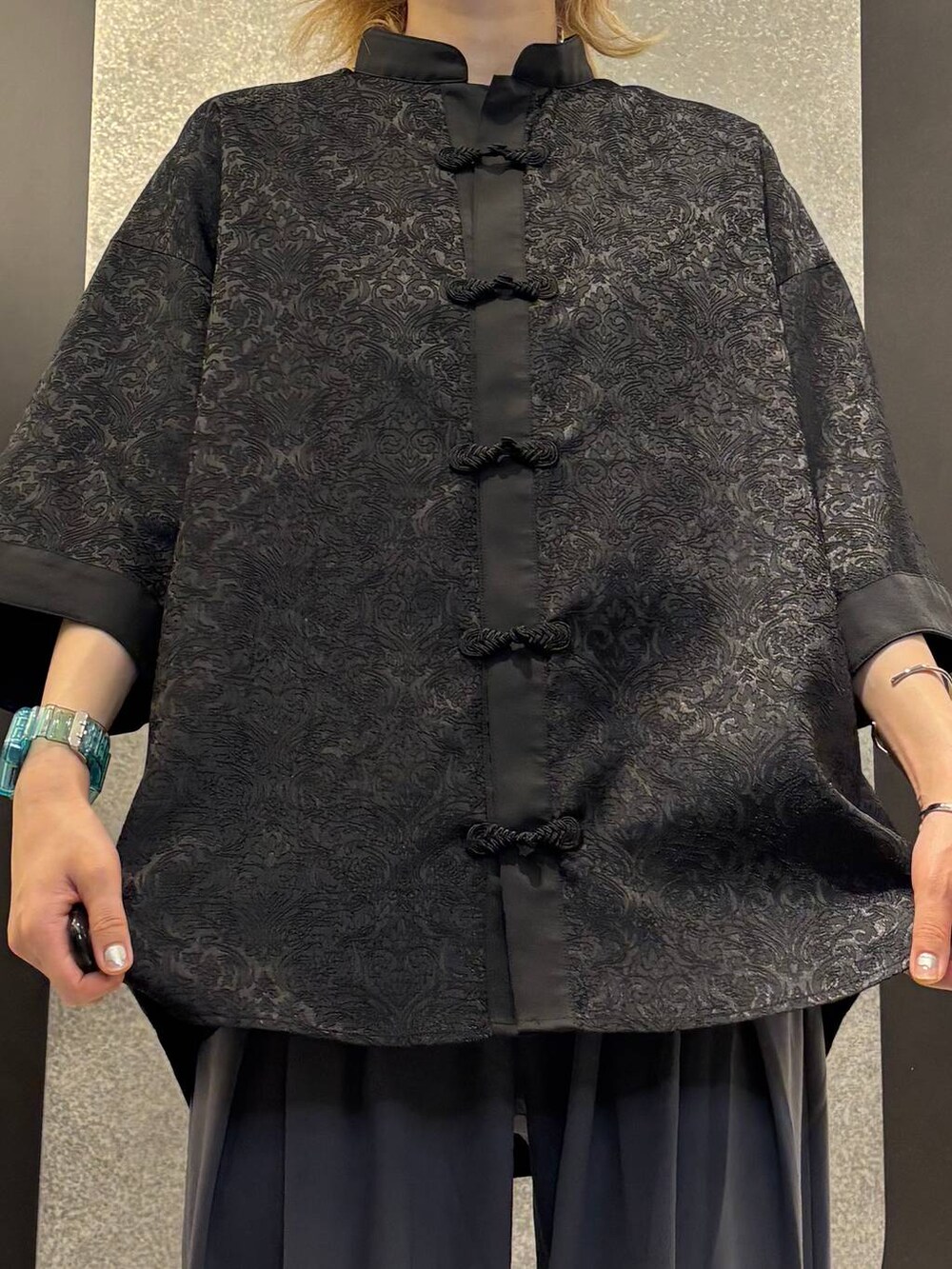 ブラック系のサンダル、グレー系のスラックス、ブラック系のシャツ/ブラウスを着用したレディースの夏コーディネートの4枚目の写真