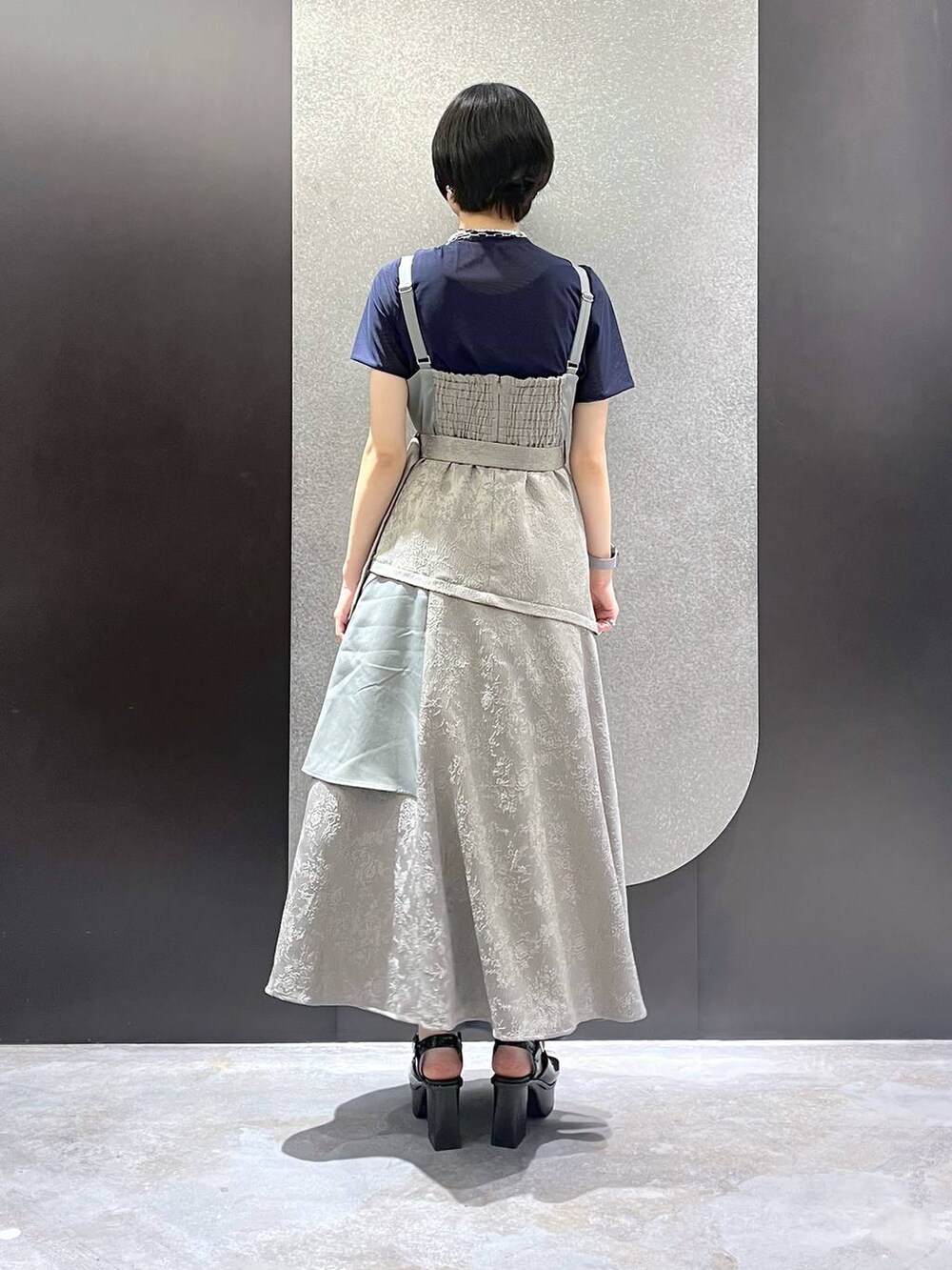 ホワイト系のサンダル、グレー系のワンピース、ブラック系のTシャツ/カットソーを着用したレディースの春コーディネートの3枚目の写真