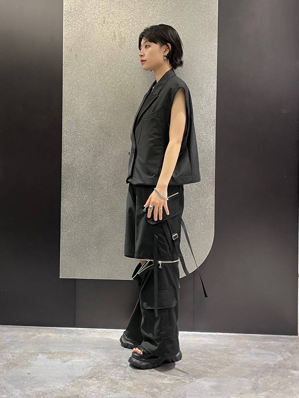 ブラック系のベスト、グレー系のTシャツ/カットソー、ブラック系のカーゴパンツを着用したレディースの夏コーディネートの2枚目の写真