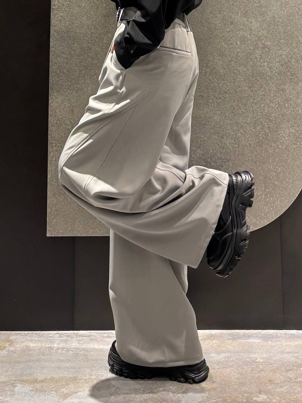 ブラック系のスニーカー、ホワイト系のブルゾン、グレー系のスラックスを着用したレディースの春コーディネートの9枚目の写真