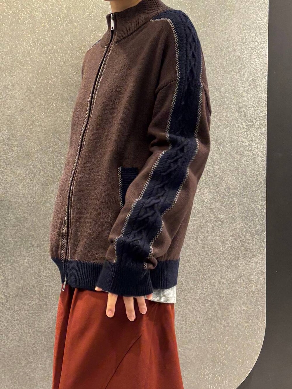 グレー系のブルゾン、オレンジ系のスラックス、グレー系のブーツを着用したレディースの冬コーディネートの5枚目の写真