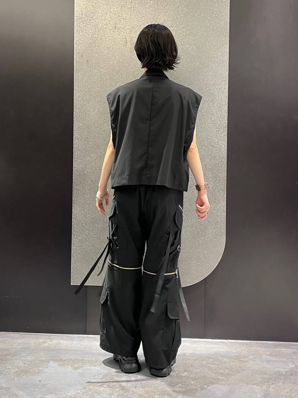 ブラック系のベスト、グレー系のTシャツ/カットソー、ブラック系のカーゴパンツを着用したレディースの夏コーディネートの3枚目の写真