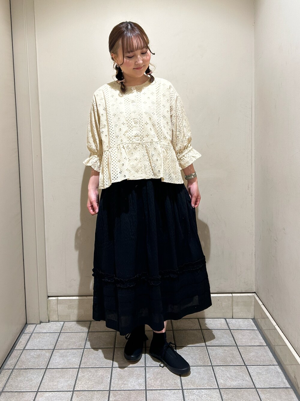 ベージュ系のシャツ/ブラウス、ブラック系のスカート、ブラック系のスニーカーを着用したレディースの春コーディネートの2枚目の写真