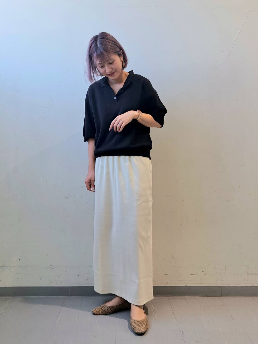 ベージュ系のトートバッグ、ベージュ系のパンプス、ホワイト系のスカートを着用したレディースの夏コーディネートの3枚目の写真