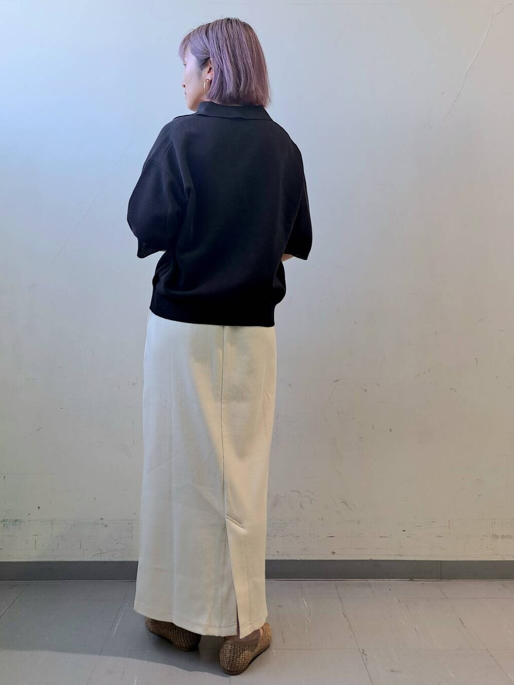 ベージュ系のトートバッグ、ベージュ系のパンプス、ホワイト系のスカートを着用したレディースの夏コーディネートの4枚目の写真