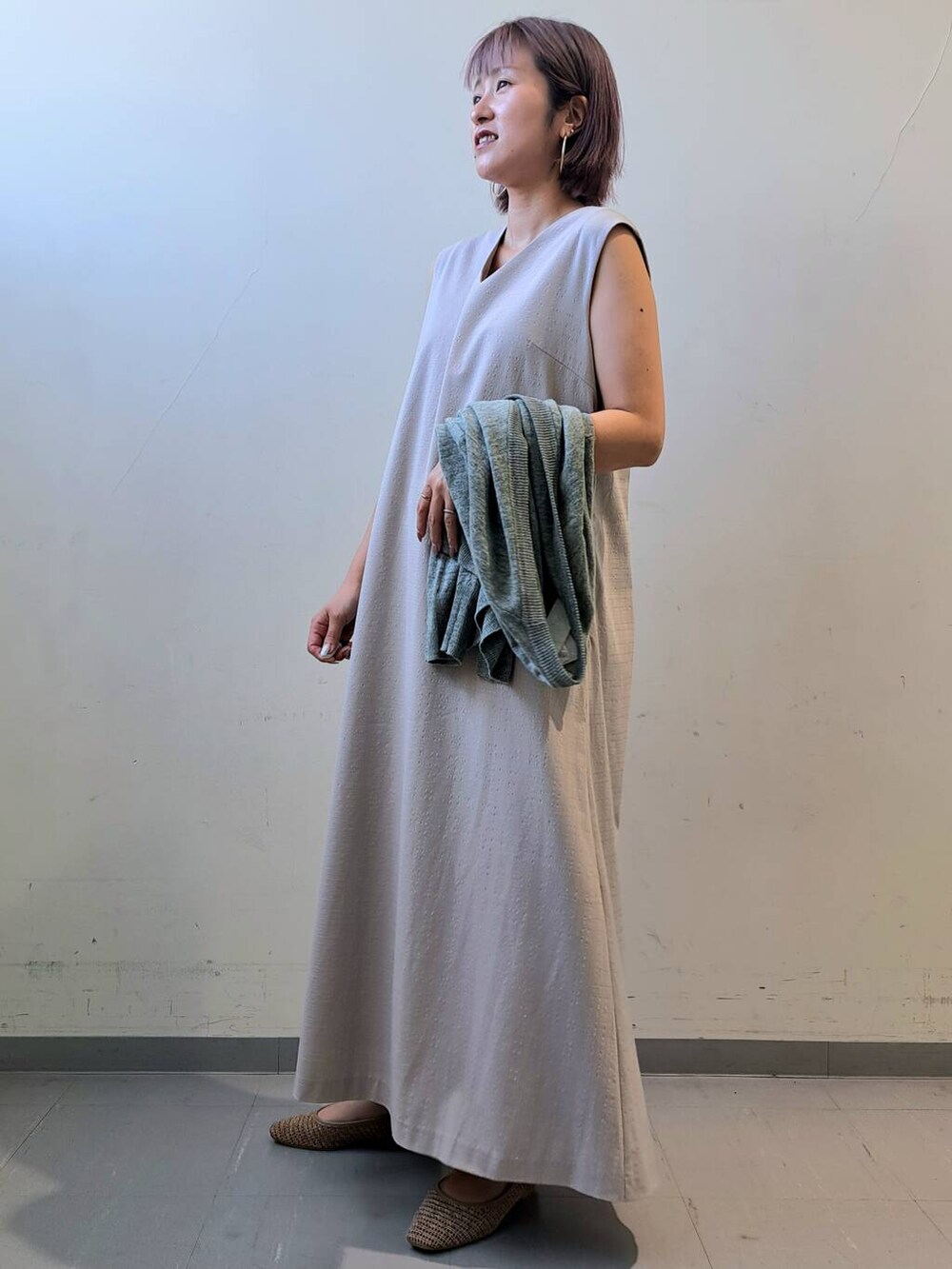 グリーン系のカーディガン/ボレロ、ベージュ系のパンプス、グレー系のワンピースを着用したレディースの夏コーディネートの2枚目の写真