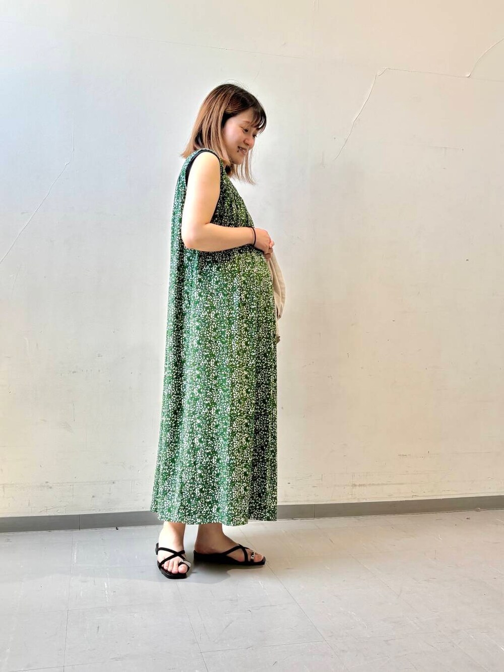 ベージュ系のカーディガン/ボレロ、グリーン系のワンピース、ブラック系のサンダルを着用したレディースの夏コーディネートの6枚目の写真