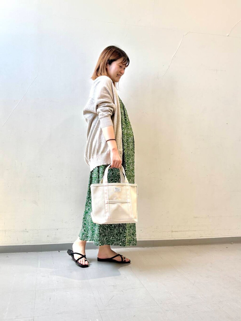 ベージュ系のカーディガン/ボレロ、グリーン系のワンピース、ブラック系のサンダルを着用したレディースの夏コーディネートの3枚目の写真