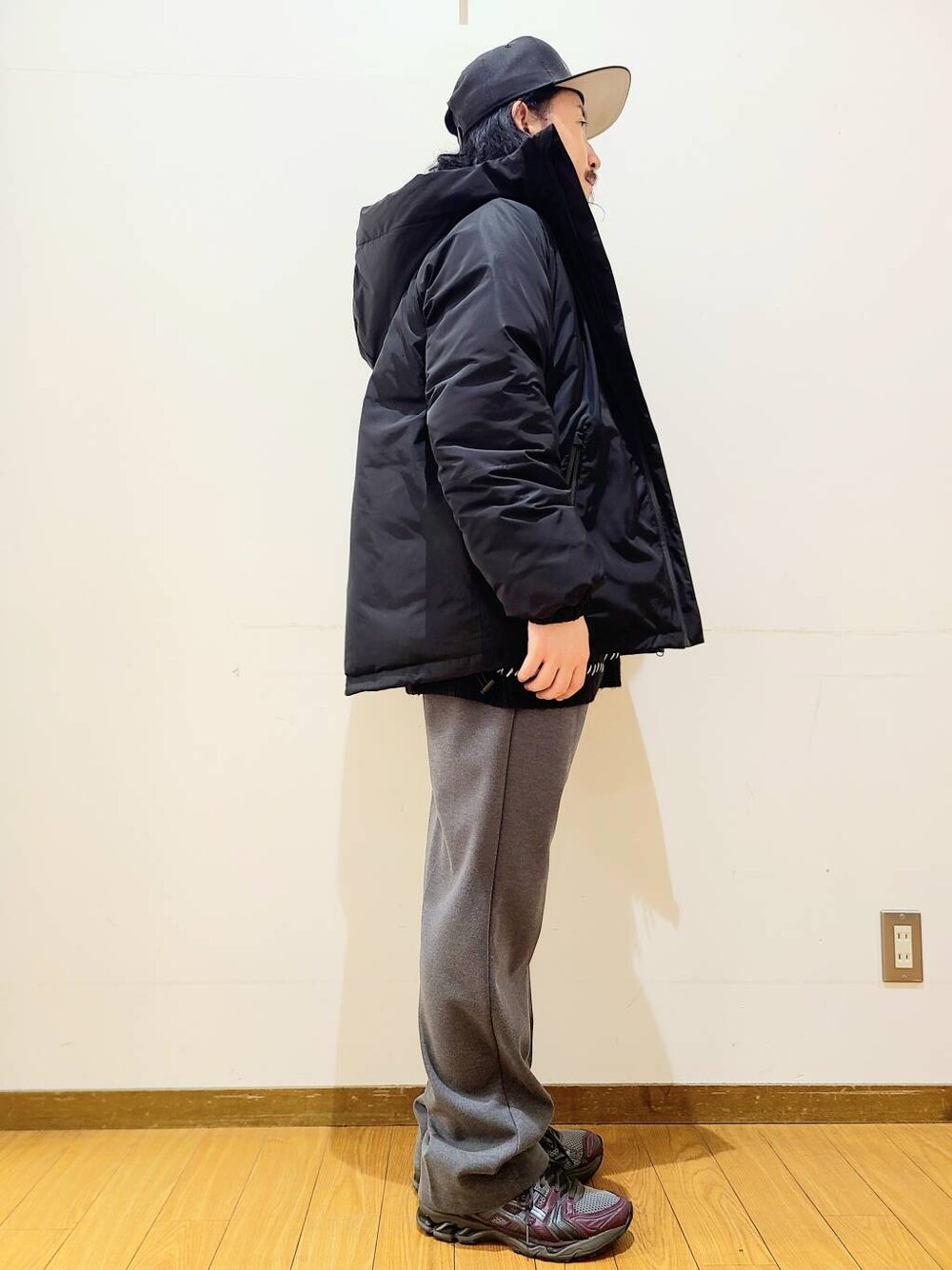 グレー系のその他パンツ、ブラック系のニット/セーター、ブラック系のダウンジャケット/コートを着用したメンズの冬コーディネートの2枚目の写真