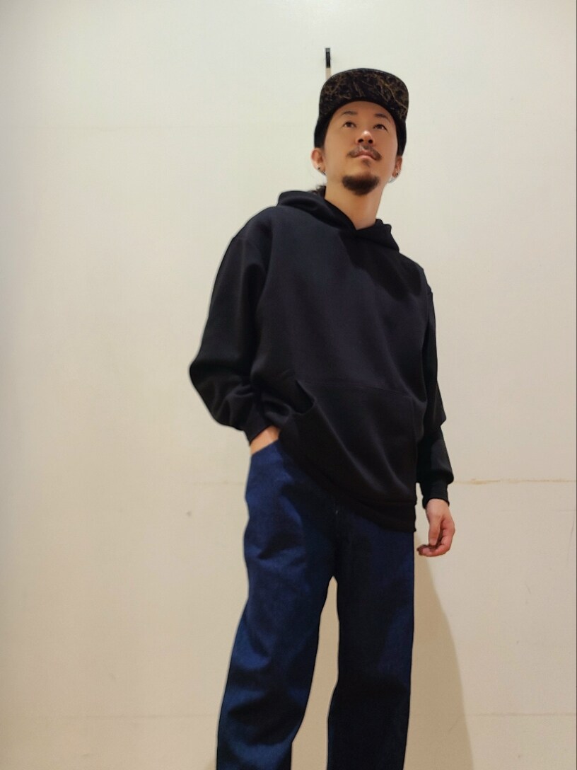 ブラック系のパーカー、ブルー系のデニムパンツを着用したメンズの秋コーディネートの6枚目の写真