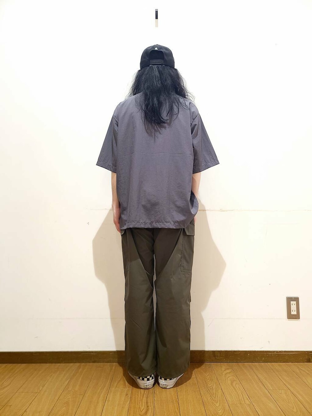 ブラック系のスニーカー、グリーン系のその他パンツ、グレー系のポロシャツを着用したメンズの春コーディネートの3枚目の写真