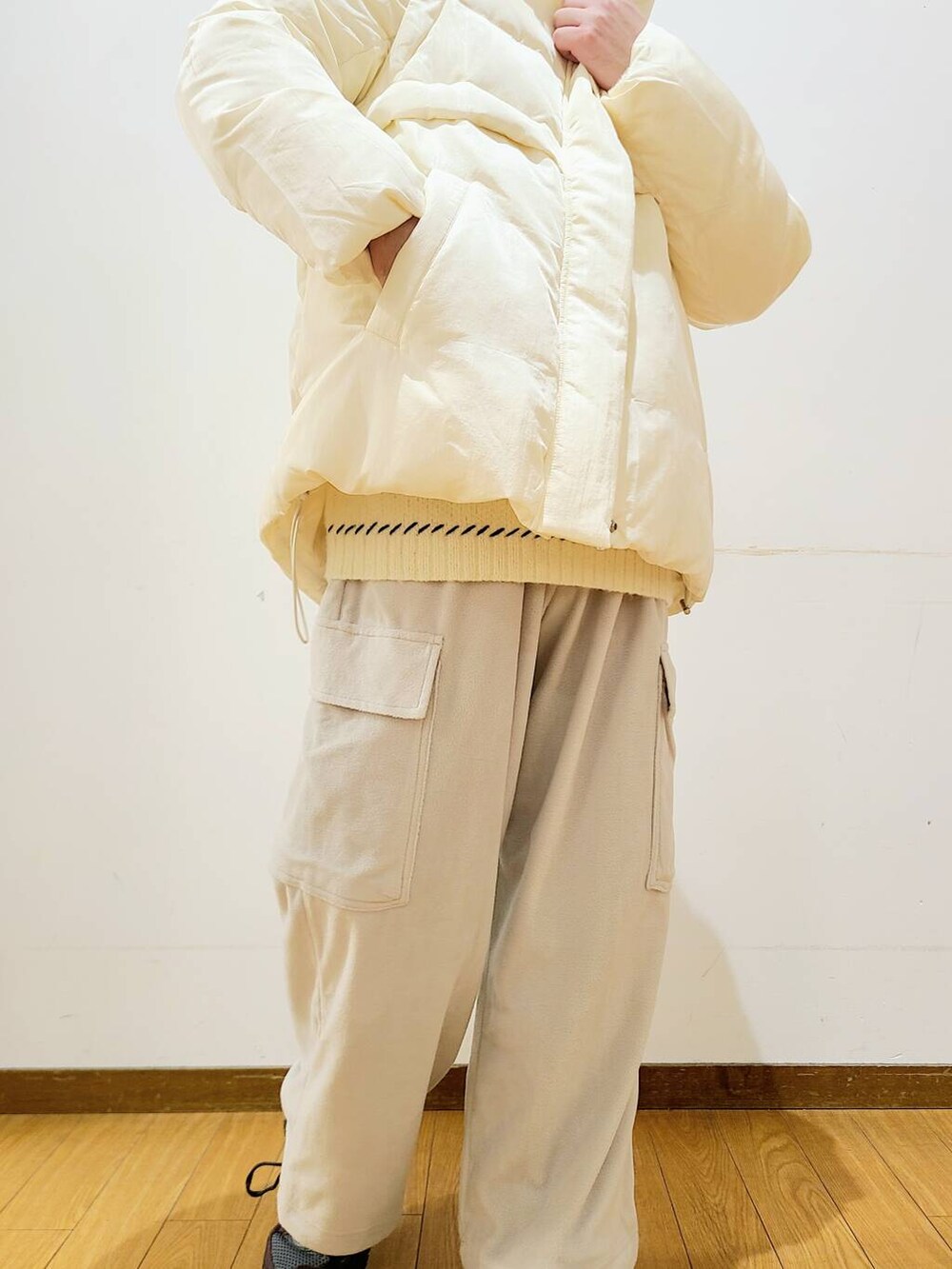 ホワイト系のダウンジャケット/コート、ホワイト系のニット/セーター、グレー系のその他パンツを着用したメンズの冬コーディネートの7枚目の写真