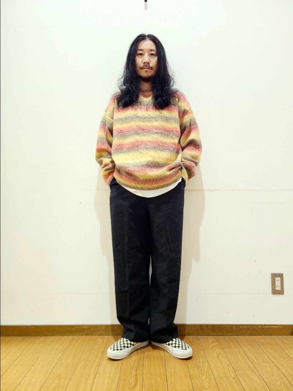 ブラック系のスニーカー、レッド系のニット/セーター、ブラック系のその他パンツを着用したメンズの秋コーディネートの2枚目の写真