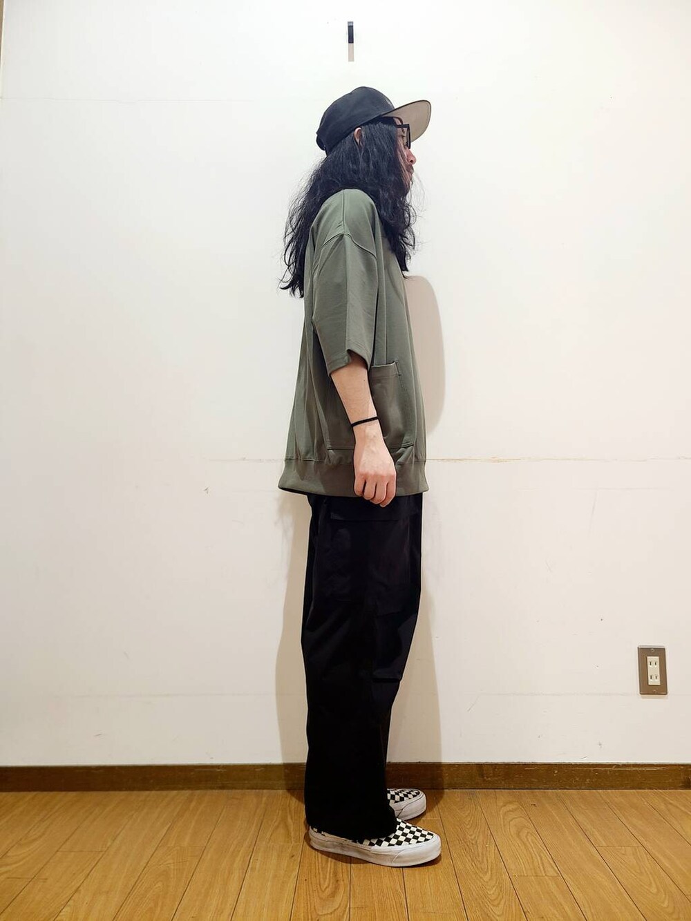 ブラック系のスニーカー、ブラック系のその他パンツ、グリーン系のTシャツ/カットソーを着用したメンズの春コーディネートの2枚目の写真