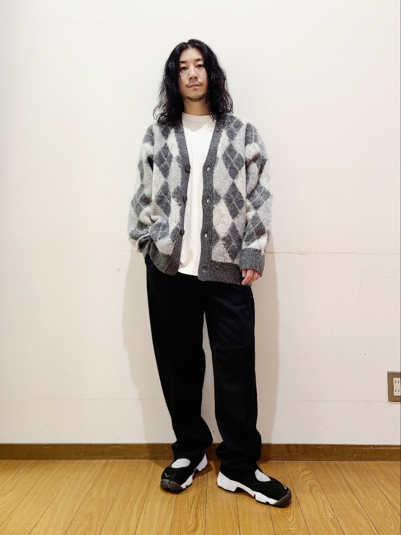 グレー系のニット/セーター、ホワイト系のTシャツ/カットソー、ブラック系のその他パンツを着用したメンズの秋コーディネートの2枚目の写真