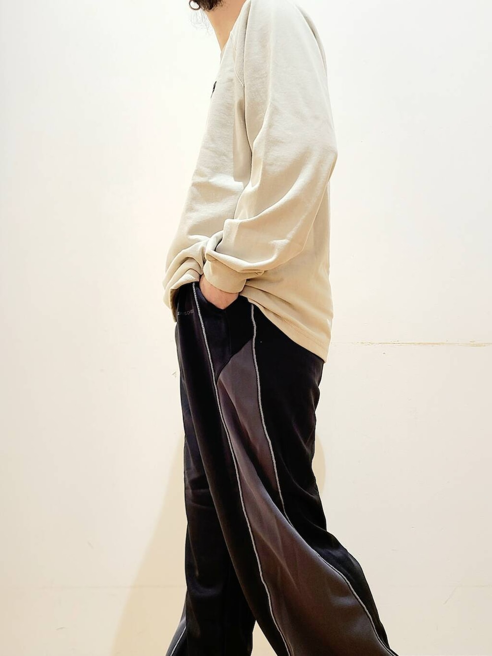 ベージュ系のTシャツ/カットソー、ブラック系のその他パンツを着用したメンズの秋コーディネートの5枚目の写真