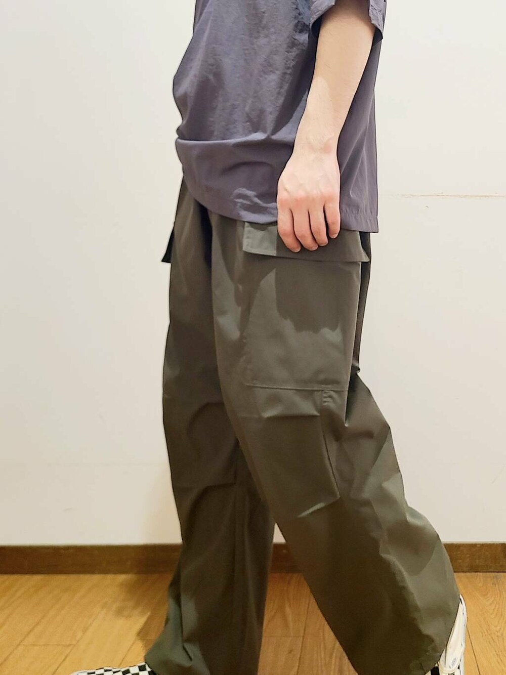 ブラック系のスニーカー、グリーン系のその他パンツ、グレー系のポロシャツを着用したメンズの春コーディネートの8枚目の写真