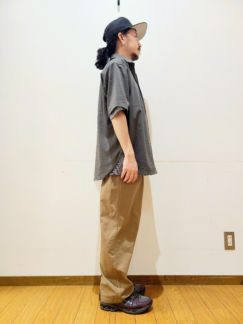 グレー系のシャツ/ブラウス、グリーン系のチノパンツ、ブラック系のキャップを着用したメンズの夏コーディネートの2枚目の写真