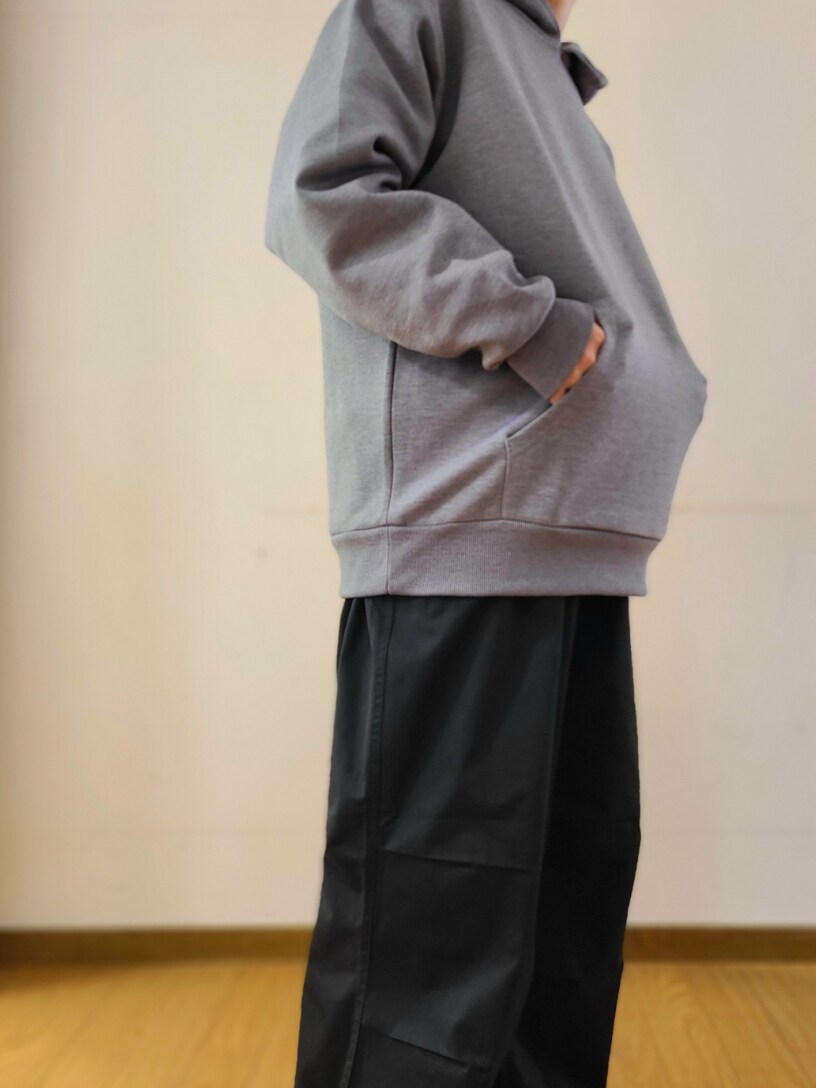 グレー系のパーカー、ブラック系のカーゴパンツを着用したメンズの春コーディネートの4枚目の写真