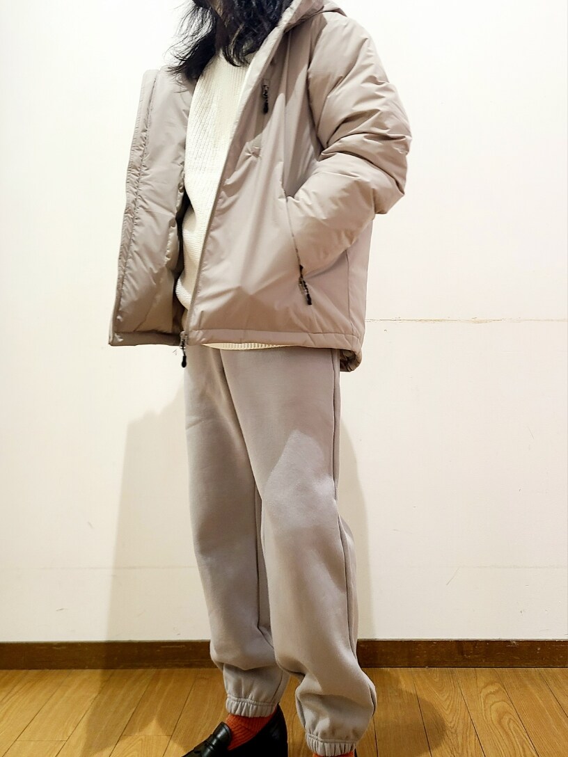 ホワイト系のニット/セーター、グレー系のスウェットパンツ、ベージュ系のダウンジャケット/コートを着用したメンズの冬コーディネートの4枚目の写真