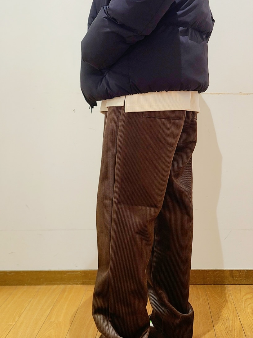 ブラック系のダウンジャケット/コート、ホワイト系のTシャツ/カットソー、ブラウン系のその他パンツを着用したメンズの冬コーディネートの6枚目の写真